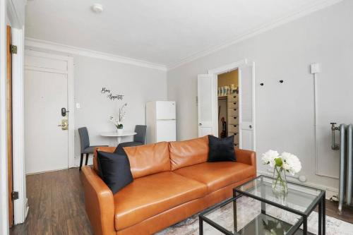 a living room with a leather couch and a table at 1BR Stylish & Modern Chicago Apartment - Kenwood 508 rep in Chicago