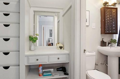 a white bathroom with a sink and a mirror at 1BR Stylish & Modern Chicago Apartment - Kenwood 508 rep in Chicago