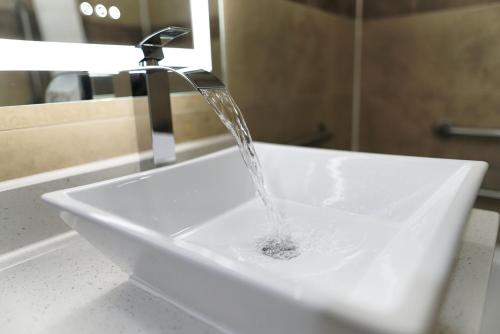 a bathroom sink with water running from a faucet at Oceans 2700 in Virginia Beach