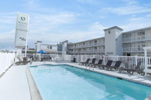 a swimming pool with chairs and a hotel at Oceans 2700 in Virginia Beach