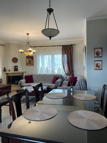 sala de estar con mesa, sillas y sofá en Athina's House, en Xanthi