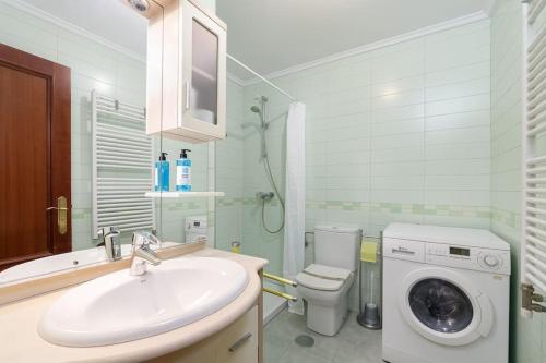 uma casa de banho com um lavatório e uma máquina de lavar roupa em Luminoso ático para dos by CABANA Rentals em Vigo