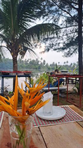a table with a plate and a vase of carrots at My Paradise in Ahangama