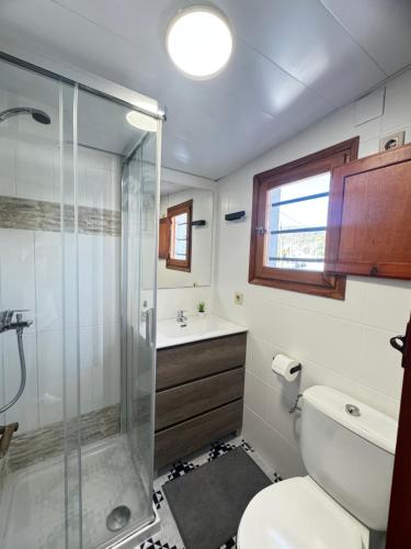 een badkamer met een douche, een toilet en een wastafel bij Attic Can Trabal in Can Trabal
