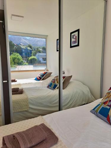 two beds in a room with a mirror at Lo de Gaston in Ushuaia