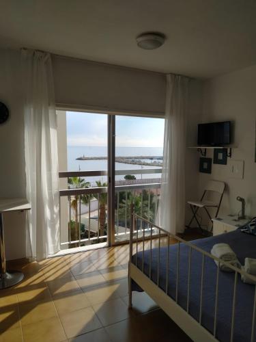 Un dormitorio con una cama y una ventana grande. en MIKIS's SeaGate Studio Aprt., en Lárnaca