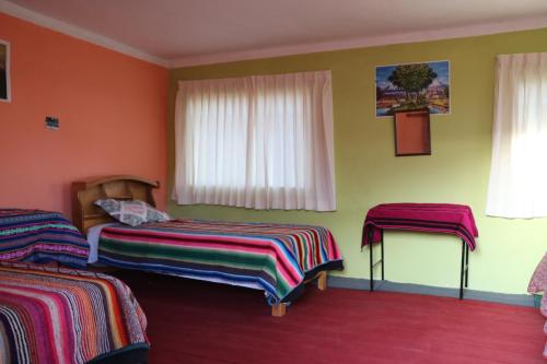 ein Hotelzimmer mit 2 Betten und einem Fenster in der Unterkunft BUNKBEDS Island Amantani in Ocosuyo