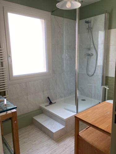 ラ・ロシェルにあるLa villa voyageのバスルーム(シャワー、バスタブ付)、窓が備わります。