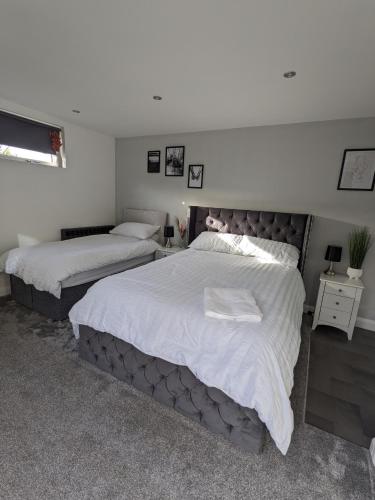 a bedroom with two beds with white sheets at Room in Detached Annex in Cantley