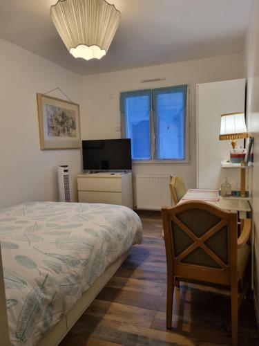 1 dormitorio con cama, escritorio y silla en 1 Chambre pour 2 dans une maison "Chez l'habitant", en Quincy-Voisins