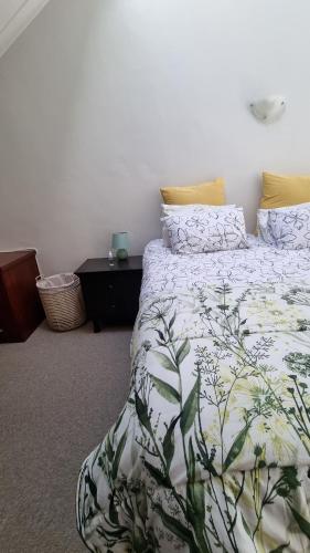 um quarto com uma cama com um edredão verde e branco em Urben Loft - Back up Power na Cidade do Cabo