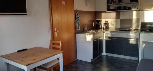 a small kitchen with a wooden table and a small table and a table at Ferienwohnung Clauss in Zwiefalten