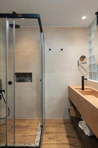 a glass shower in a bathroom with a sink at Raviewha Luxury Apartments in Ravdhoúkha