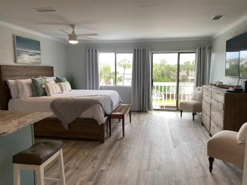 um quarto com uma cama grande e uma varanda em Destin Bliss! Your Dream Studio Condo on Holiday Isle! em Destin