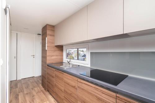 a kitchen with white cabinets and a black counter top at Amadria Park Camping Sibenik Mobile Homes in Šibenik