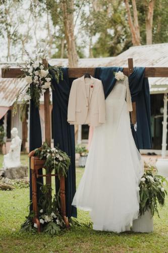 a wedding dress and jacket hanging on a fence at Long Beach Club Krabi in Ao Nang Beach