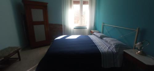 Bett in einem blauen Zimmer mit Fenster in der Unterkunft Da Teresa in Siderno Marina