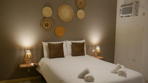 a bedroom with a large white bed with two lamps at Park View Hostel & Suites in Manta