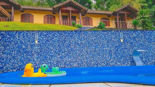 a swimming pool with a toy in front of a house at Chalés Canton Suisse in Nova Friburgo