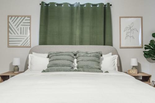 a bedroom with a bed with a green curtain at 10 Mins to Beach - 2BR Private Pool + Spa + Grill in Vero Beach