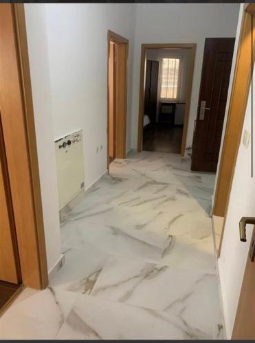 Zimmer mit weißem Marmorboden und Flur in der Unterkunft Besmir in Pristina