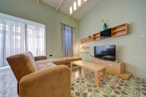 Una televisión o centro de entretenimiento en Sapphire Residences - Apartments & Penthouse In Central Sliema By Shortletsmalta