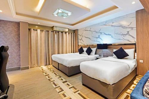 a hotel room with two beds and a couch at Trans World Hotel in Dubai