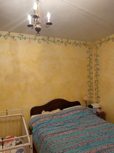 a bedroom with a bed and a chandelier at Demeure de prestige in Varennes-sur-Allier