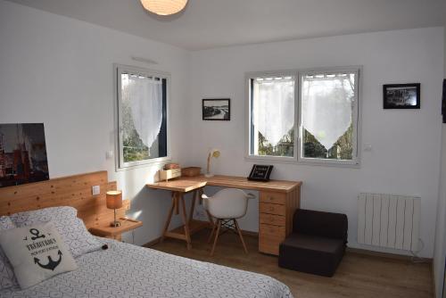 a bedroom with a bed and a desk with a chair at Ker Moumousse in Trébeurden