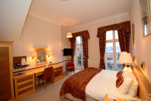 a hotel room with a bed and a desk at The Crescent Hotel in Scarborough