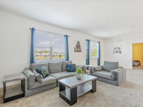 a living room with two couches and a table at 6BR w Heated Pool + 9MI to Disney + Sleeps 14 in Kissimmee