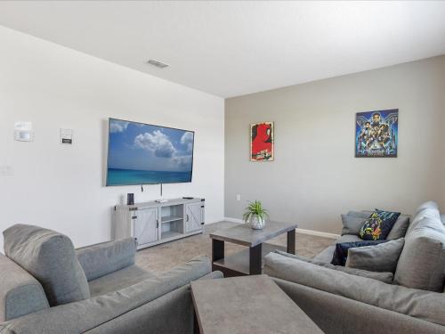 a living room with two couches and a flat screen tv at 6BR w Heated Pool + 9MI to Disney + Sleeps 14 in Kissimmee