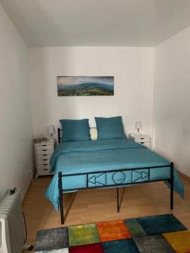 a bedroom with a bed with blue pillows at Chambres Senonches centre-ville in Senonches