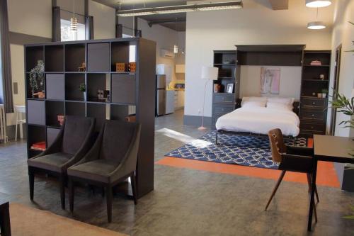 Schlafzimmer mit einem Bett, einem Schreibtisch und Stühlen in der Unterkunft Suite #B, Industrial Styling, AC in Halifax