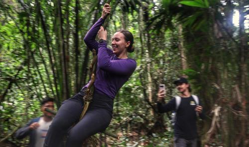 una mujer en el bosque con sus brazos en el aire en Amazon Nativo Lodge, en San Pedro