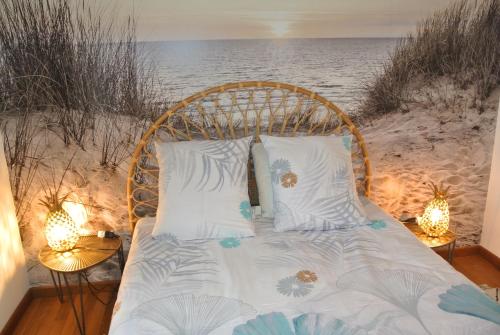 Una cama en la playa con luces. en Gîte Les Chênes, en Villeneuve-les-Sablons