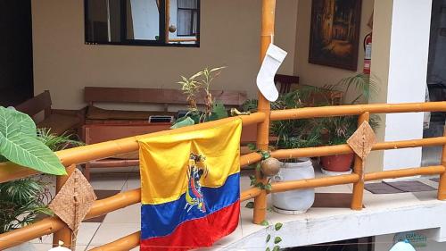 a flag hanging on a railing in a house at Hostal y Complejo Turístico La Rueda in Guaranda