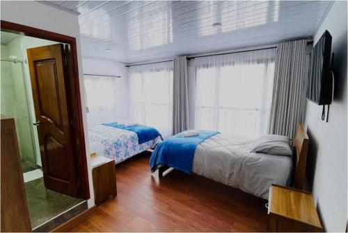 - une chambre avec 2 lits et un miroir dans l'établissement Villa Mongui, à Monguí