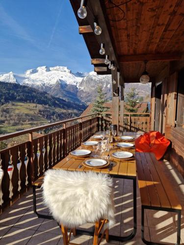 a table on a balcony with a view of mountains at Chalet de Manigod in Manigod