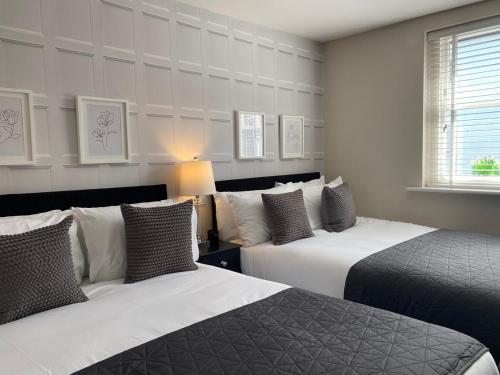 two beds in a hotel room with two beds sidx sidx sidx at The Hamptons by Brighton Holiday Lets in Brighton & Hove