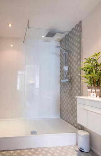 a bathroom with a shower with a bath tub at The Hamptons by Brighton Holiday Lets in Brighton & Hove