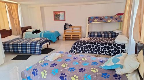 a room with two beds and a bunk bed at Hostal y Complejo Turístico La Rueda in Guaranda