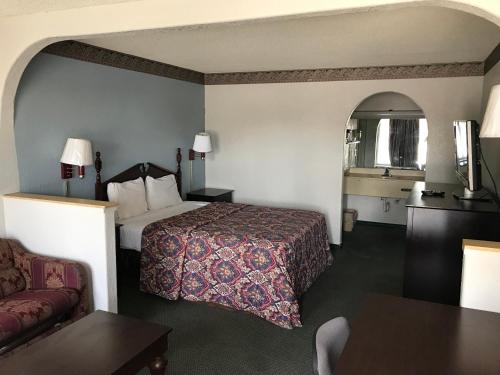 a hotel room with a bed and a couch at executive inn & suites in Lufkin