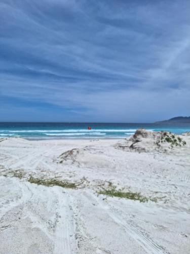 una playa de arena con el océano en el fondo en Apartamento Praia do Forte - Centro en Cabo Frío