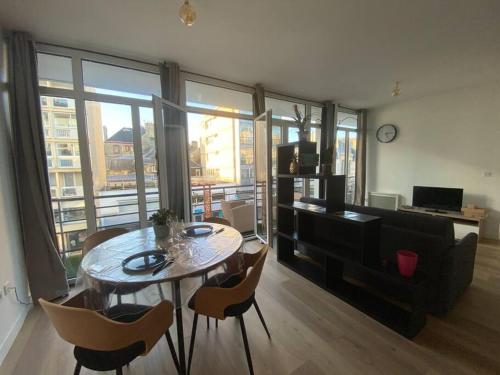 a living room with a table and chairs and a couch at Un extérieur en ville in Cherbourg en Cotentin