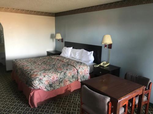 a hotel room with a bed and a table at executive inn & suites in Lufkin