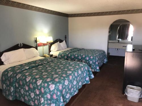 a hotel room with two beds and a window at executive inn & suites in Lufkin