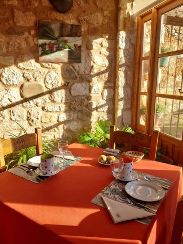 una mesa con un mantel rojo y gafas. en Hotel Rural El Adarve, en Ayllón