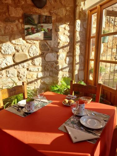 a table with a red table cloth and glasses on it at Hotel Rural El Adarve in Ayllón
