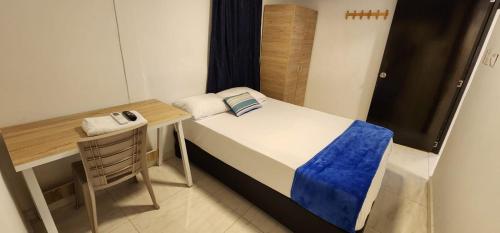 a small room with a bed and a desk at Edificio Regata INN in Buenaventura